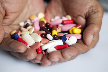pile of medicine pills tablets capsules in a both hands in white background