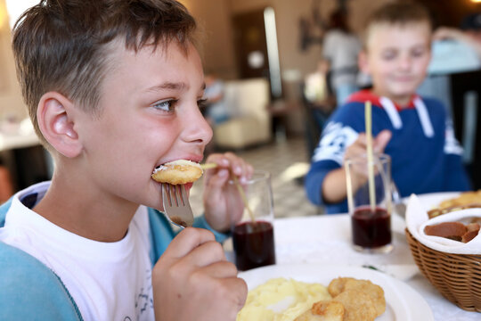 Two Kids Eating Nuggets