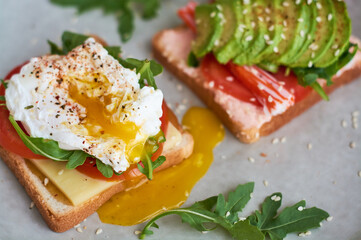 Healthy and beautiful breakfast of boiled eggs benedict, fresh vegetables of avocado, tomatoes and figs, watermelon on toast with black and strong coffee.
