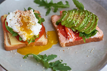 Healthy and beautiful breakfast of boiled eggs benedict, fresh vegetables of avocado, tomatoes and figs, watermelon on toast with black and strong coffee.