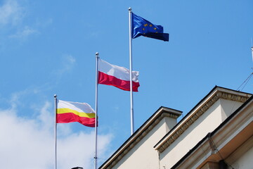 White-yellow-red, red-white and blue flags against the blue sky