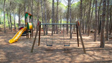 children's playground in the middle of a forest of maritime pines
