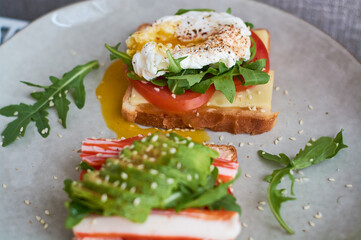 Healthy and beautiful breakfast of boiled eggs benedict, fresh vegetables of avocado, tomatoes and figs, watermelon on toast with black and strong coffee.