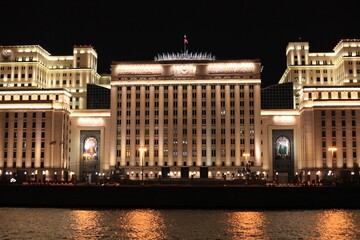 Fototapeta na wymiar Colorful panorama of the night city with neon lights. Main building of the Ministry of Defense of Russia