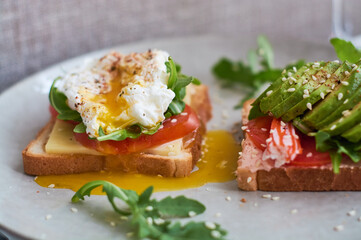 Healthy and beautiful breakfast of boiled eggs benedict, fresh vegetables of avocado, tomatoes and figs, watermelon on toast with black and strong coffee.