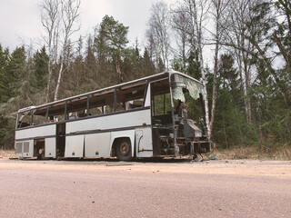 Broken bus abandoned in countryside. Old forgotten gray bus on the road in woods. landscape with...
