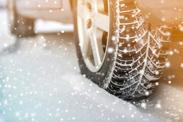 Close-up of car wheels rubber tires in deep winter snow. Transportation and safety concept.