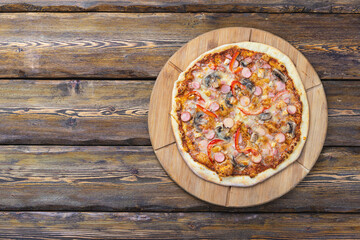cutting board with hot testy pizza on wooden background,top view 