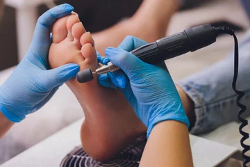 Foto op Plexiglas Pedicure Proces pedicure close-up, voeten polijsten, onherkenbare mensen. wazig gezicht.