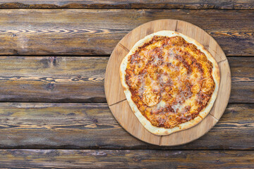 cutting board with hot testy pizza on wooden background,top view 