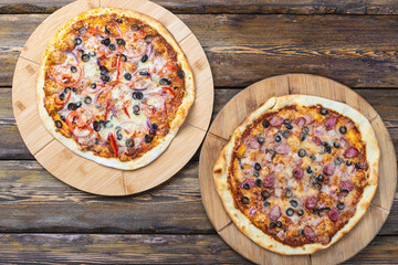 cutting boards with hot testy pizzas on wooden background,top view 