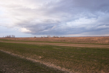 Dramatic pre-storm sky over the field. Spring landscape.
