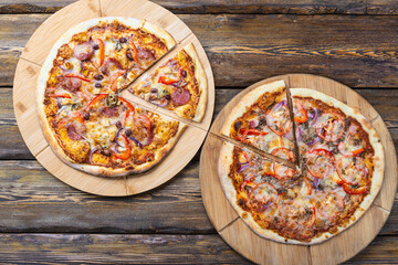 cutting boards with hot testy pizzas on wooden background,top view 