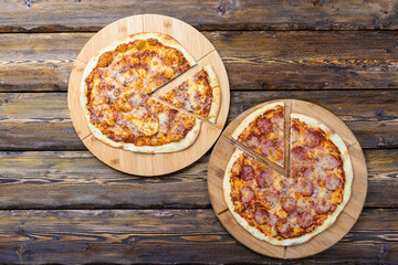 cutting boards with hot testy pizzas on wooden background,top view 