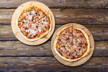 cutting boards with hot testy pizzas on wooden background,top view 