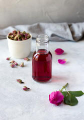 Fototapeta na wymiar A bottle of rose water made of fresh rose petals, natural organic product