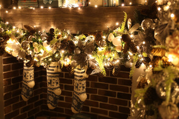 christmas socks with gifts hang on the fireplace at night
