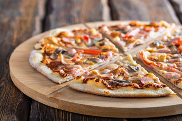 cutting board with hot testy pizza on wooden background,close view 