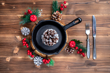 Vintage cast iron skillet on rustic wood background. Food background with copyspace. New Year and Christmas menu in a cafe and restaurant.