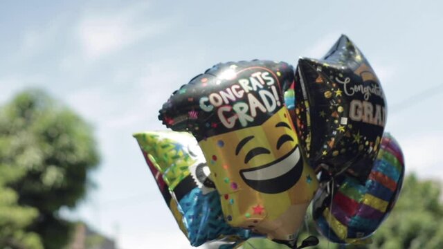 Graduation Balloons Float in the Air for Celebration, Slow Motion, Blue Sky