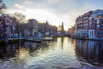 Idyllic view on Amsterdam : water in canals and  sunset sky and awe medieval architecture