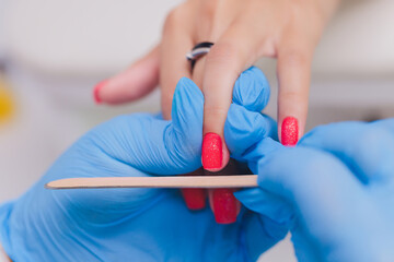 woman doing manicure in a beauty salon. Close-up of hands.
