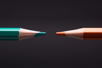 Two colour pencils in the colours of orange and teal, the famous contemporary colour scheme