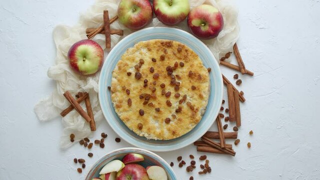 Homemade apple cake pie on blue ceramic plate with fresh apples and cinnamon sticks