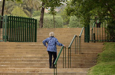 Old woman climbing stairs © Marta Pujolràs