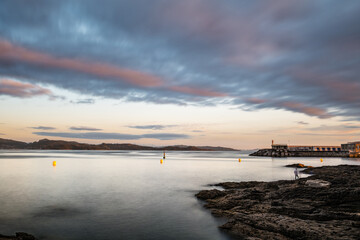 Obraz premium Rocks and small lighthouse on a calm cloudy evening in the Rias Baixas in Galicia, Spain. Long exposure.