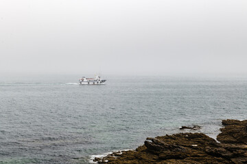 An empty passenger boat cruises the Ria de Pontevedra back from the outer islands on a foggy Summer...