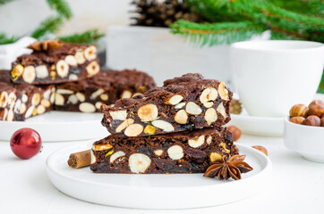 Panforte. Traditional Italian Christmas dessert with nuts and dried fruit on a white background. Horizontal, copy space.
