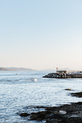 Small boat sailing back to port on a calm clear evening in the Rias Baixas in Galicia, Spain.