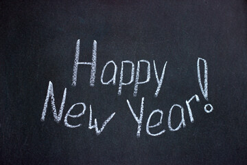 Fototapeta premium The inscription on the chalkboard Happy New Year in the form of a smile. Greeting lettering