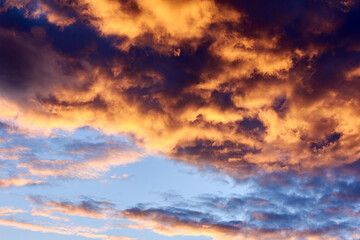 Naklejka na ściany i meble Orange sunset sky with large cumulus clouds