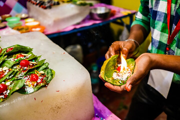 fire paan, a special variety of flaming betel leaf being prepared in the hands of seller