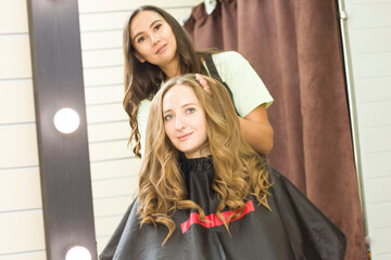 young woman gets her hair done in a beauty salon. Wind up curls