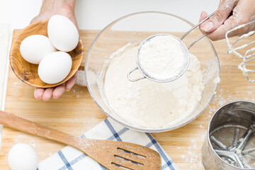 young woman making dough. on the table: flour, eggs, salt