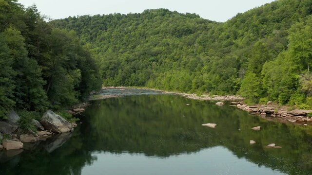 Steady slow then faster drone flight down the Cheat River by the Jenkinsburg Bridge near Mt Nebo and Morgantown in summer