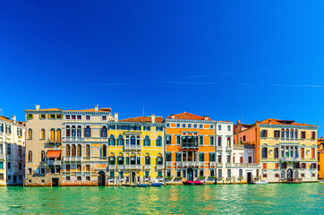 Fototapeta na wymiar Grand Canal waterway with row of colorful multicolored palace buildings in Cannaregio sestiere Venice historical city centre, blue clear sky background copy space, summer day, Veneto Region, Italy