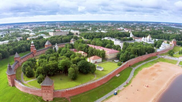 Panoramic aerial view of the Volkhov River and the old town of Veliky Novgorod, the red brick Kremlin in the rays of the setting sun and natural attractions of Russia.