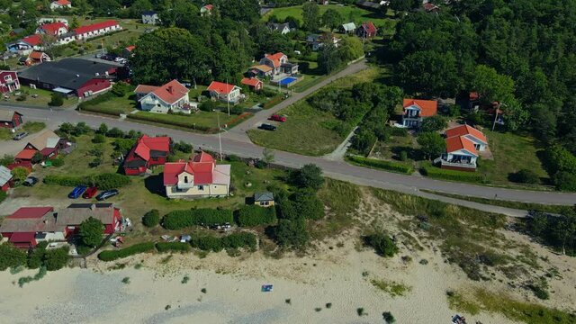 Beachfront Houses And Fishing Village Of B&ouml;da Socken  On A Sunny Summer Day In Byxelkrok, &Ouml;land, Sweden.  - aerial drone descending