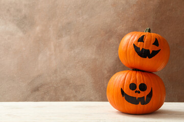 Funny halloween pumpkins against brown background, space for text