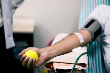 selective focus of blood collection during blood donation and ball in palm for squeezing