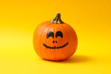 Pumpkins with smiling face on yellow background