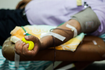 selective focus of blood collection during blood donation and ball in palm for squeezing