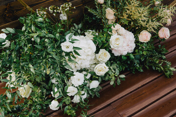 Beautiful fresh greenery and flowers adorn the wedding arch.