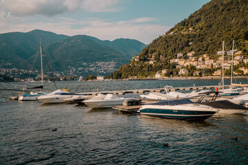 Fototapeta na wymiar Sunset view of private motor and sailing boats on Lake Como, Lombardy, Italy