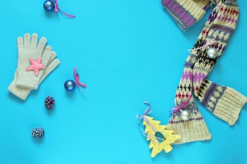 Christmas background, New Year's toys, scarf, gloves on bright blue paper, top view, flat lay