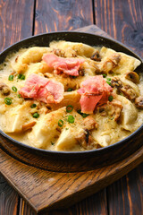 Close up view of fried meat dumplings with bacon and mushroom sauce